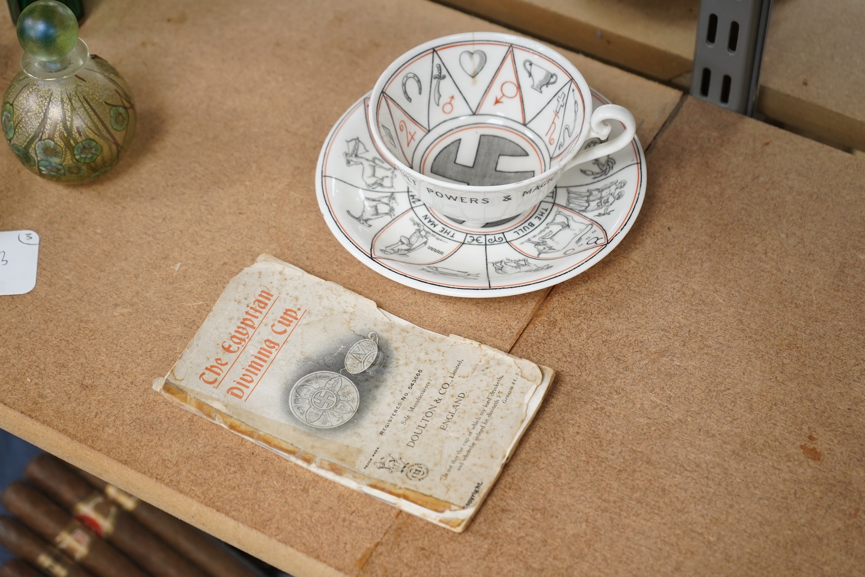 A Royal Doulton 'The Egyptian Divining cup and saucer', with booklet, numbered RN543665